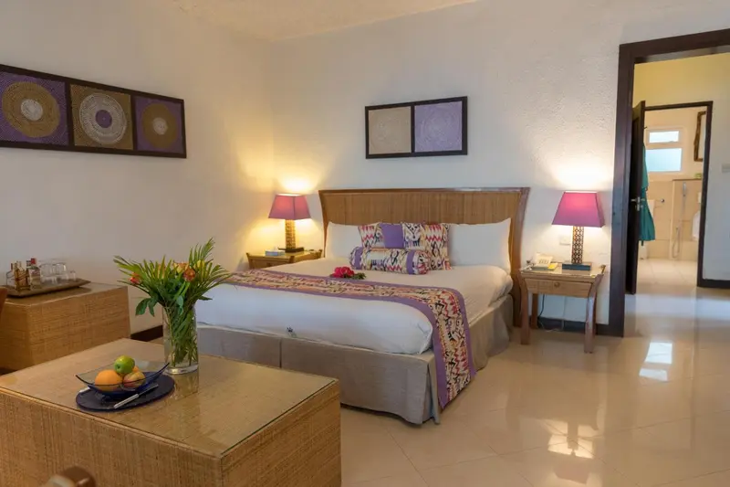 Une chambre lumineuse avec un grand lit et une décoration florale.
