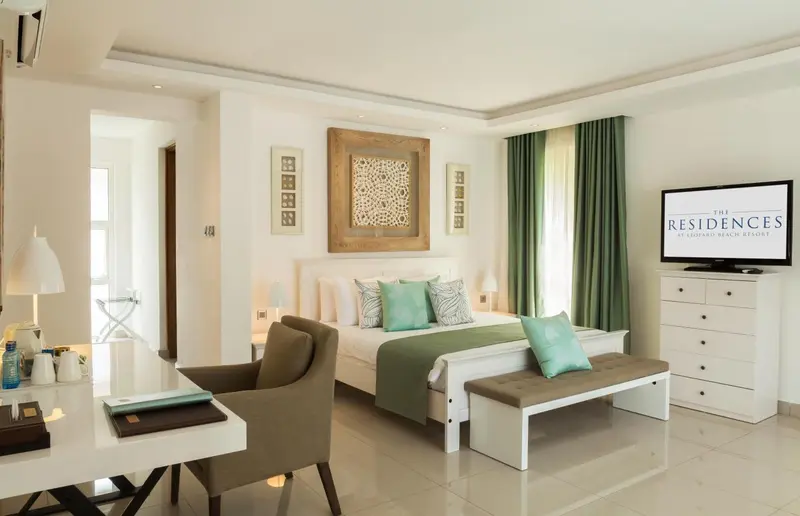 Une chambre lumineuse avec un grand lit et un coin salon.
