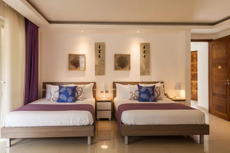 Une chambre avec deux lits simples et une décoration murale.