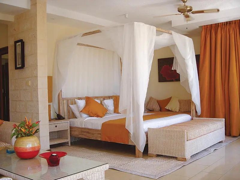 Une chambre lumineuse avec un grand lit à baldaquin et une décoration colorée.