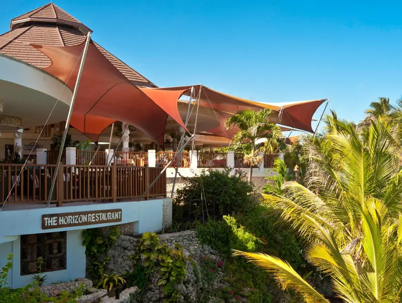 Terrasse ombragée avec vue sur la végétation tropicale.