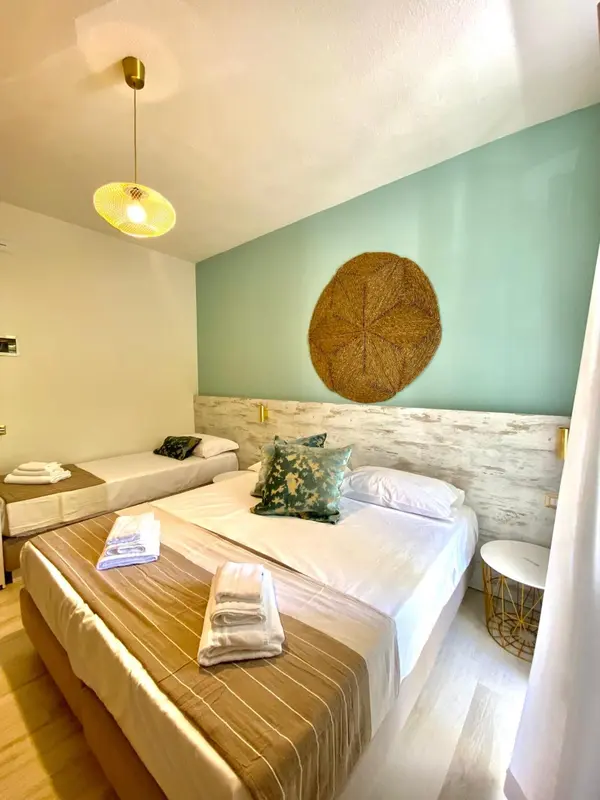 Une chambre lumineuse avec un grand lit et une décoration murale.