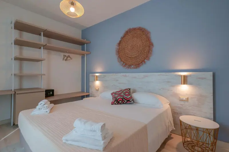 Une chambre lumineuse avec un grand lit et une décoration murale.