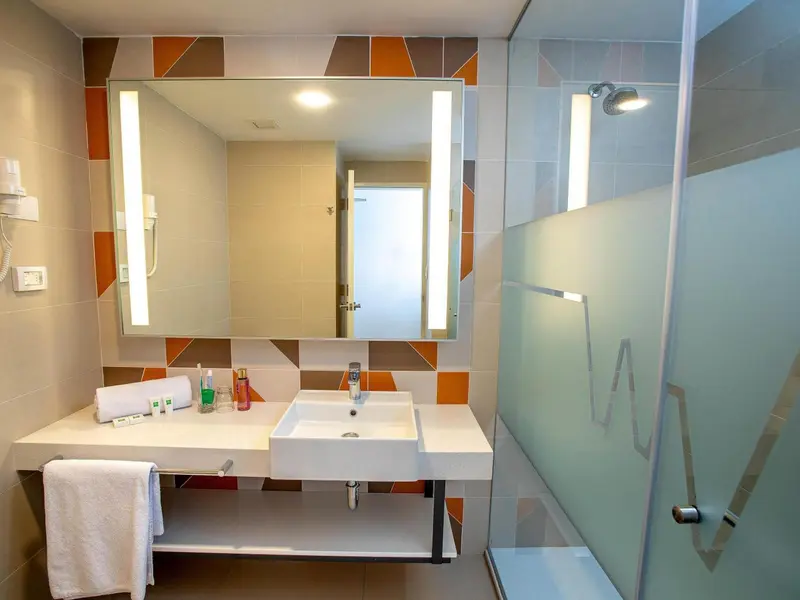 Une salle de bain moderne avec une douche vitrée et un grand miroir.