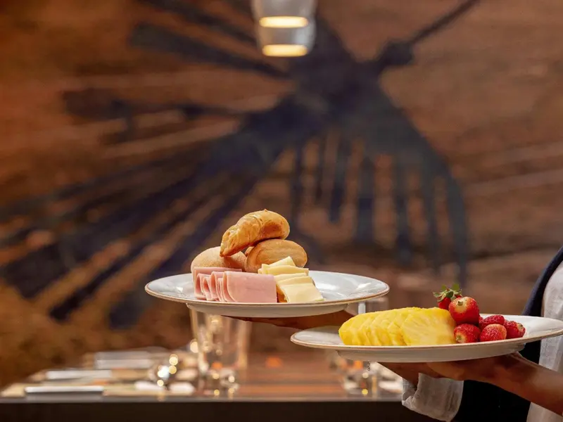 Assiette de viennoiseries et de fruits frais présentées sur une table.