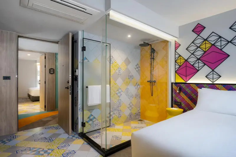 Une chambre moderne avec une douche à l'italienne vitrée et un décor coloré.