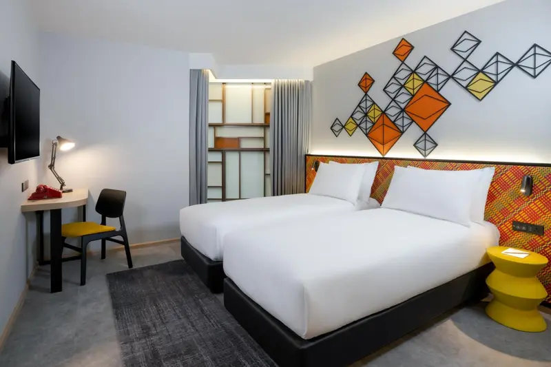 Une chambre lumineuse avec un lit double et un espace bureau.