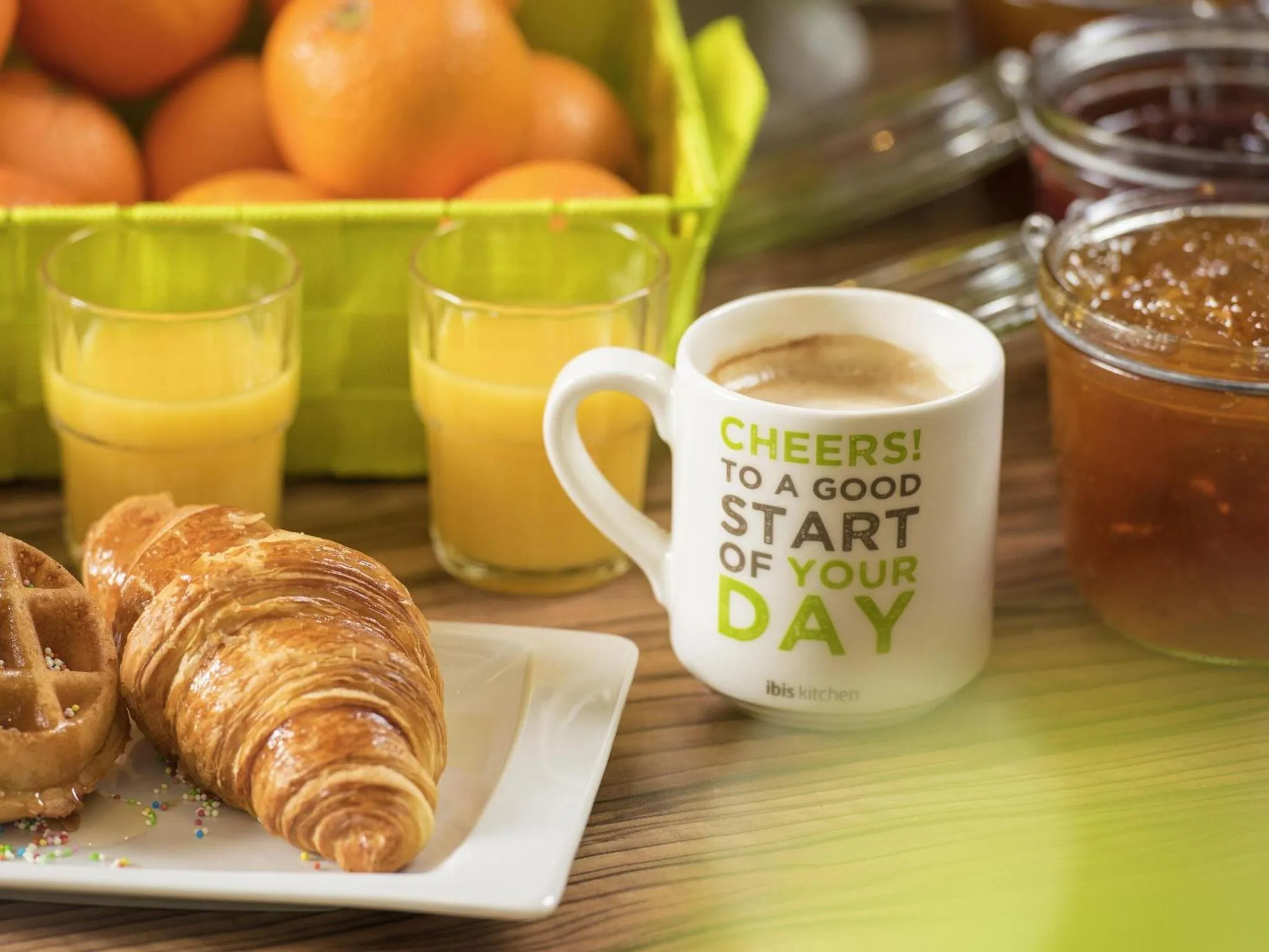 Une nature morte avec des viennoiseries, des jus de fruits et une tasse de café.