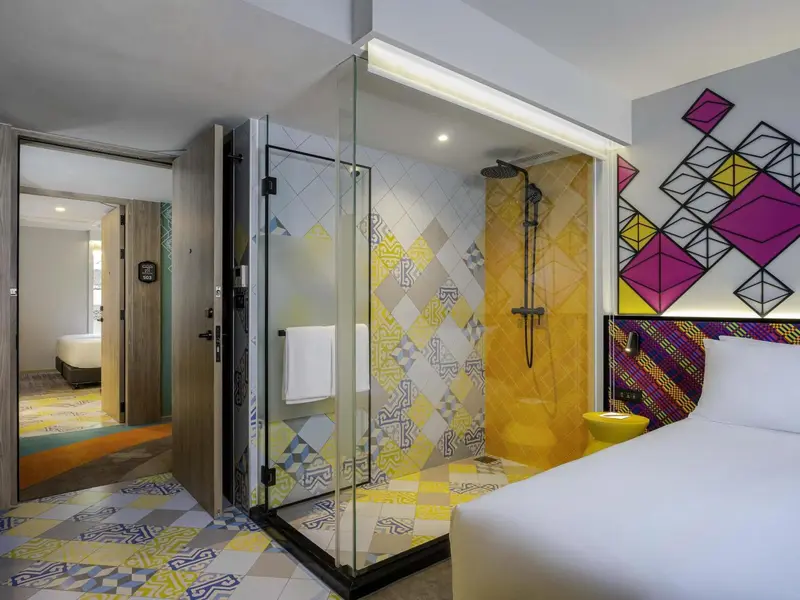 Une salle de bain lumineuse avec une douche à l'italienne et un décor coloré.