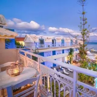 Terrasse avec mobilier de jardin et vue sur les bâtiments et la mer.