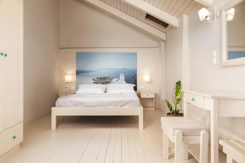 Une chambre lumineuse avec un grand lit et une décoration marine.