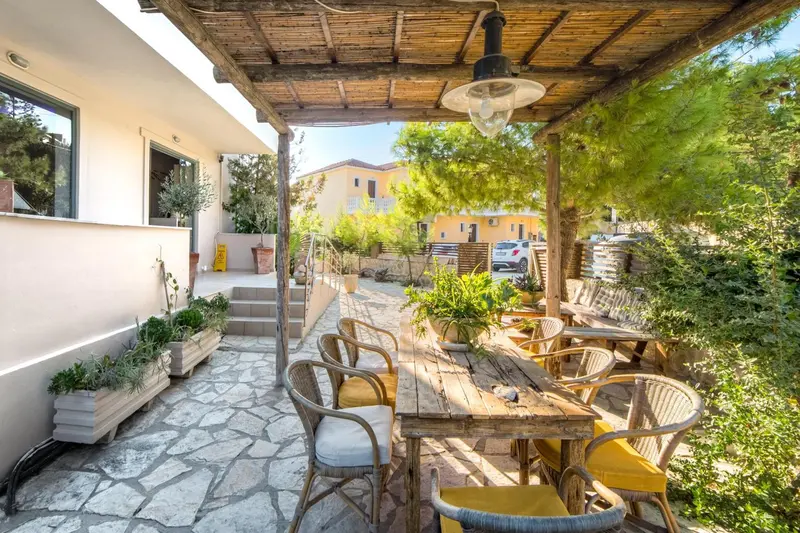 Une terrasse ombragée avec des tables et des chaises en bois.