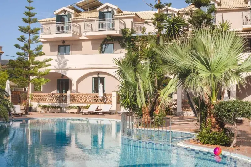 Bâtiment beige avec des balcons et une piscine au premier plan.
