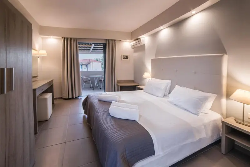 Une chambre lumineuse avec un grand lit et un accès à une terrasse.