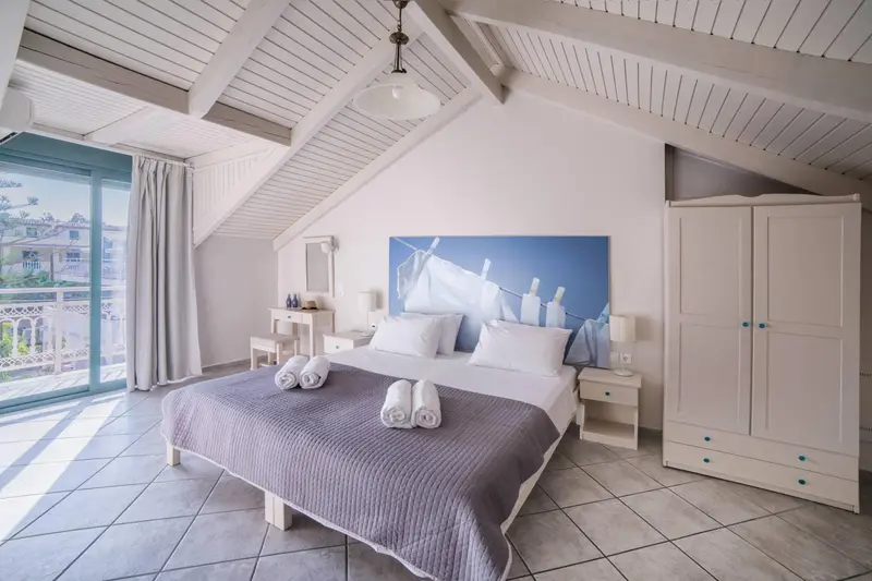 Une chambre lumineuse avec un grand lit et un accès à une terrasse.