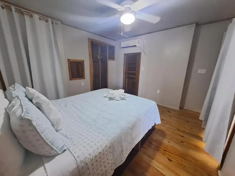 Une chambre lumineuse avec un grand lit recouvert d'une courtepointe.