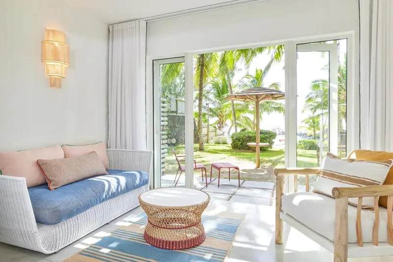 Espace de détente intérieur avec canapés et vue sur une terrasse ensoleillée.
