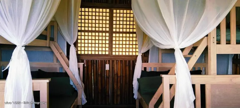 Lits superposés drapés de voilages blancs dans une chambre lumineuse.