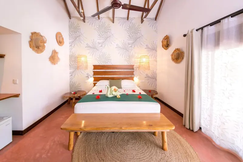 Une chambre lumineuse avec un grand lit décoré de fleurs.
