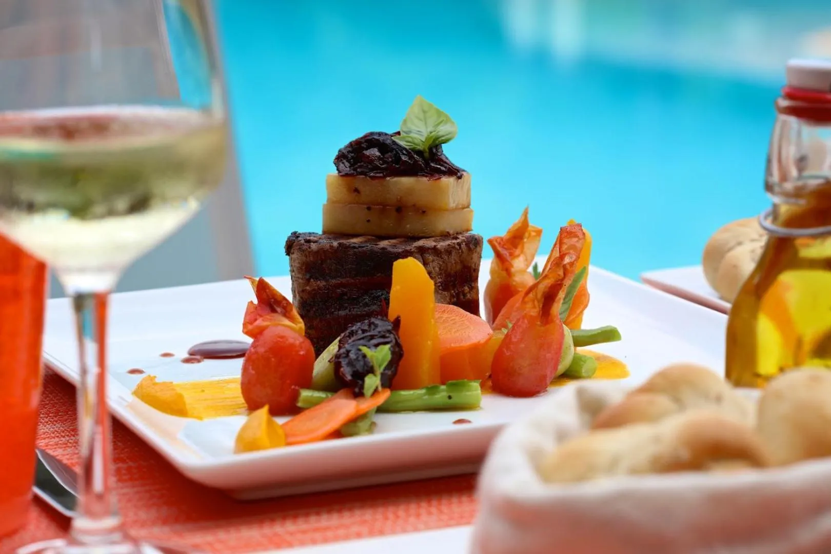 Assiette de viande servie avec des légumes et accompagnée d'une boisson et de pain.