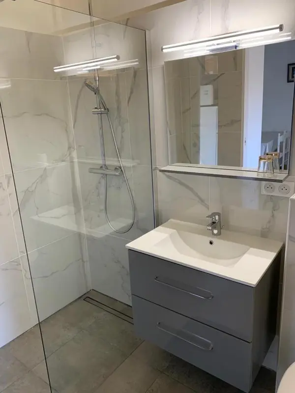 Une douche à l'italienne moderne avec un lavabo intégré.