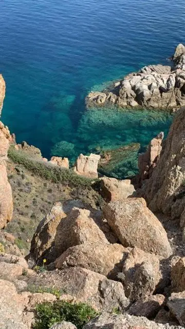 Côte rocheuse surplombant une eau turquoise et limpide.