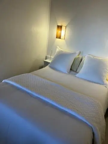Un lit blanc est fait dans une chambre lumineuse.