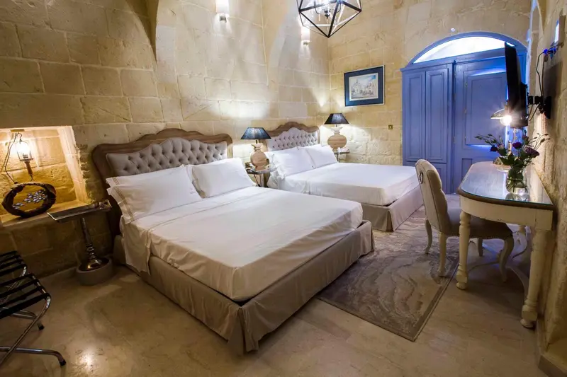 Une chambre à coucher avec deux lits simples et un bureau.