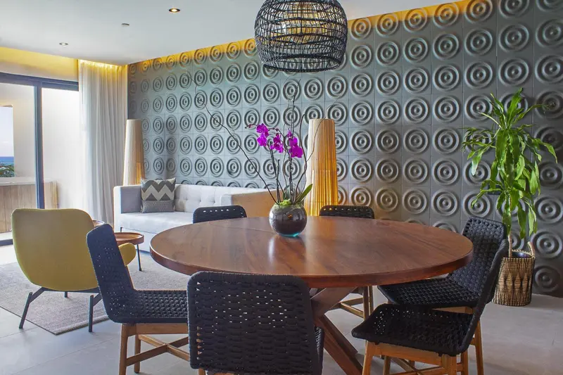 Une table ronde en bois est entourée de chaises dans un espace intérieur décoré.