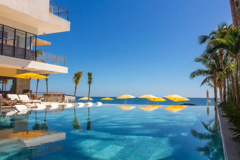 Une piscine à débordement offre une vue sur la mer et le ciel bleu.