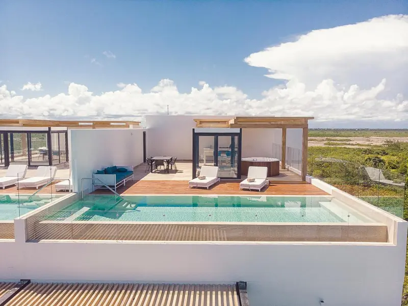 Terrasse avec piscine et mobilier de détente.
