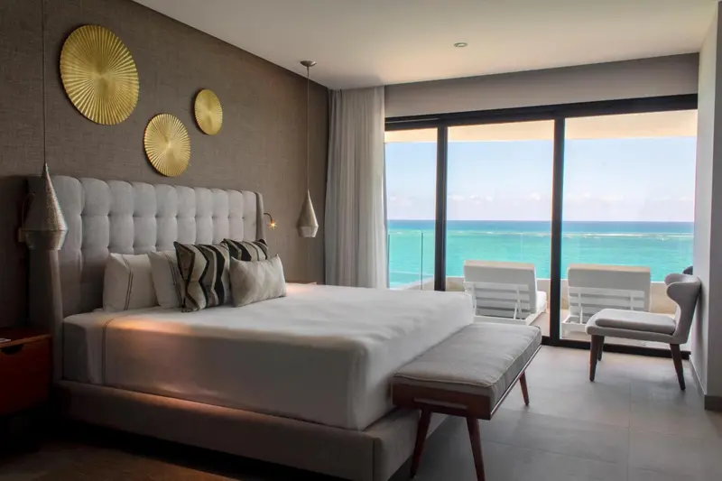 Une chambre lumineuse avec un grand lit et une vue sur la mer.