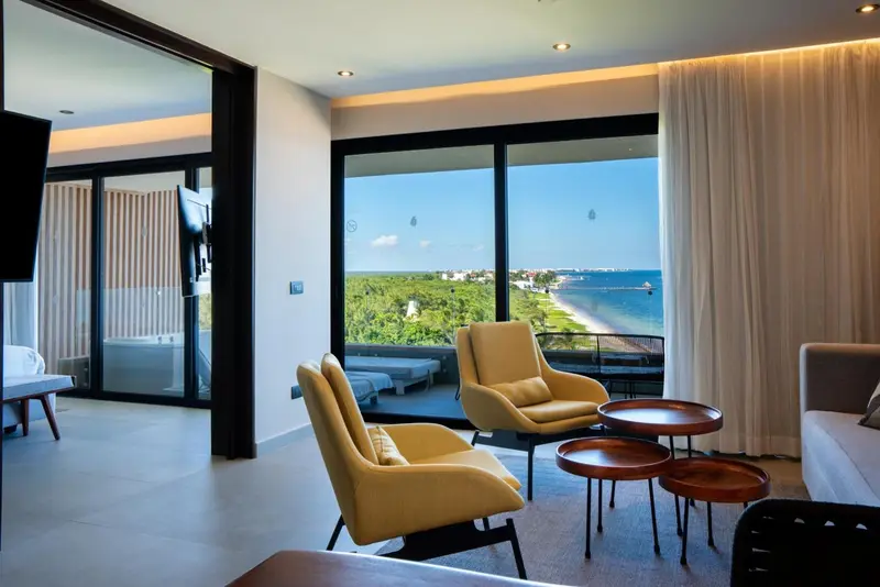 Espace de détente intérieur avec fauteuils et vue sur la mer.