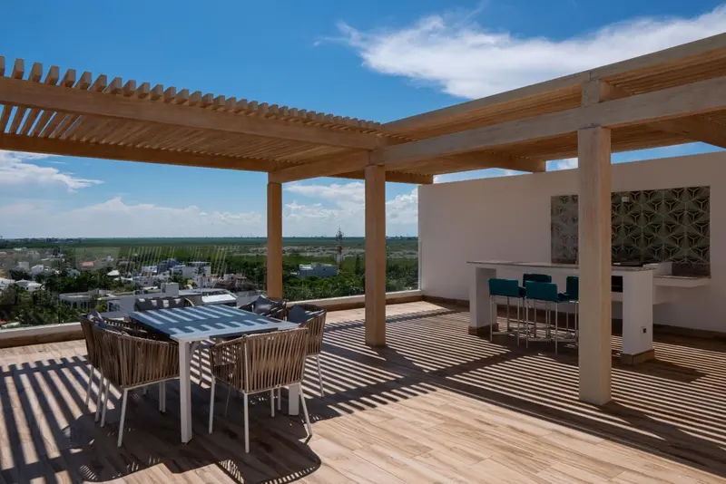 Terrasse aménagée avec mobilier de jardin et vue sur un paysage verdoyant.