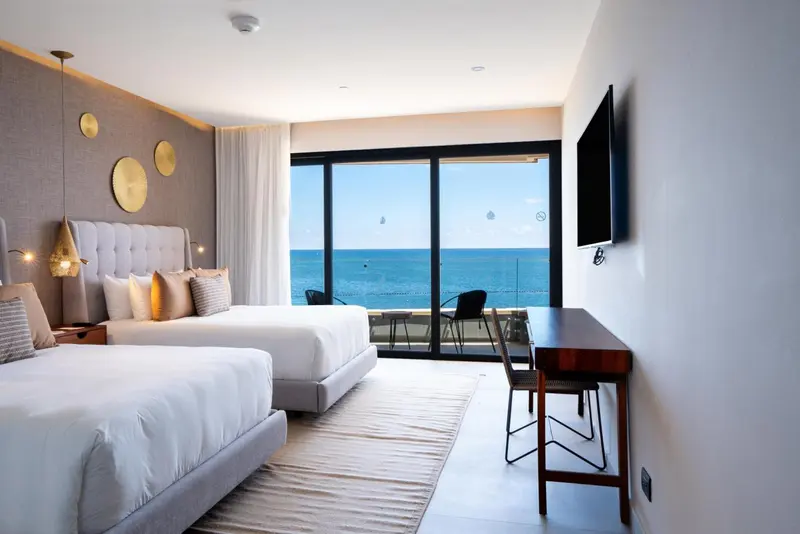 Une chambre lumineuse avec un grand lit et une vue sur la mer.
