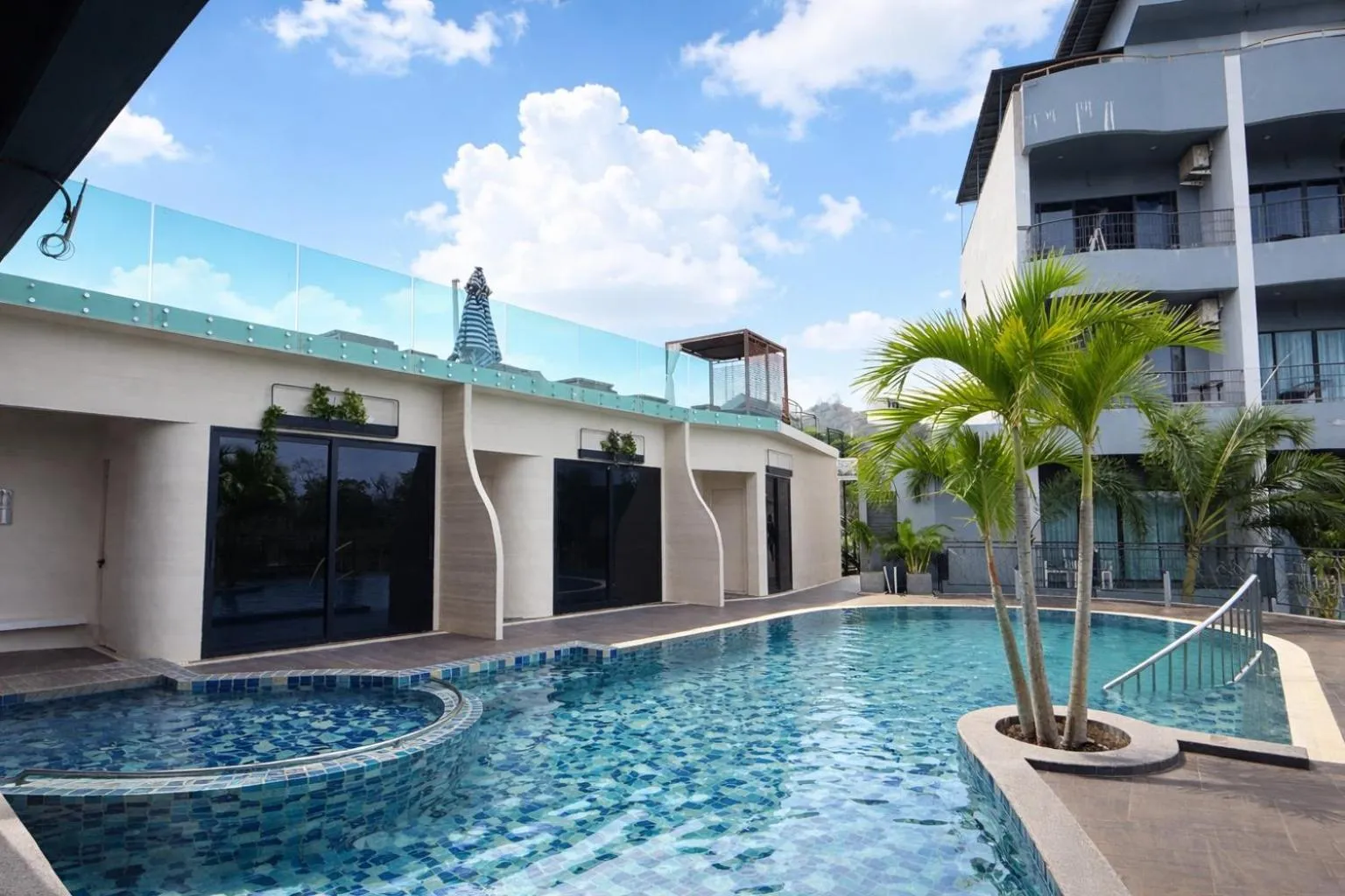 Une piscine rectangulaire avec un espace de détente ombragé.