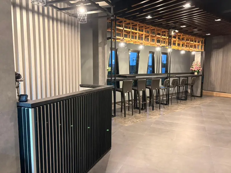 Un comptoir d'accueil moderne avec des tables et des chaises dans un espace lumineux.