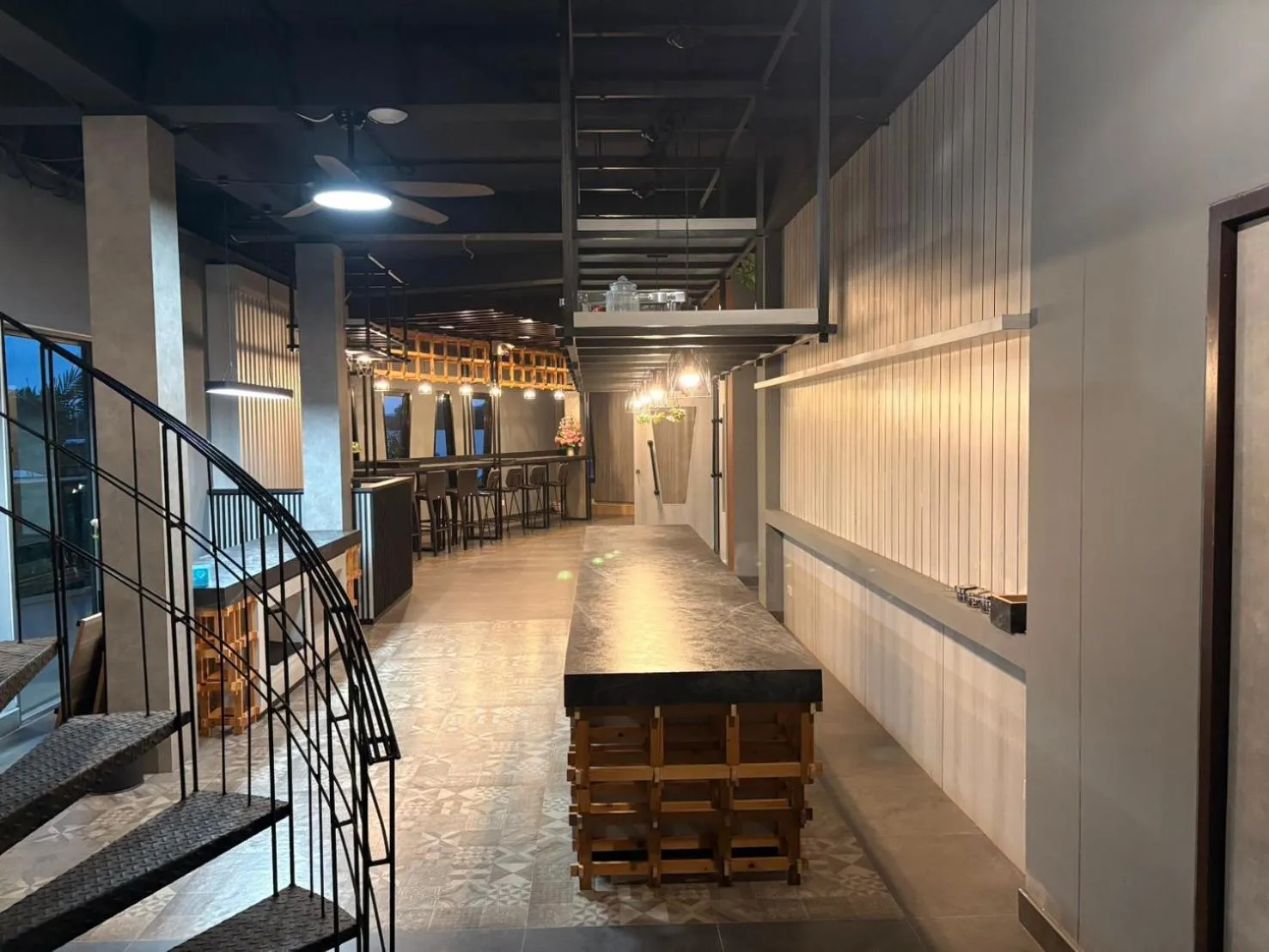 Un long espace intérieur avec un comptoir et des escaliers.