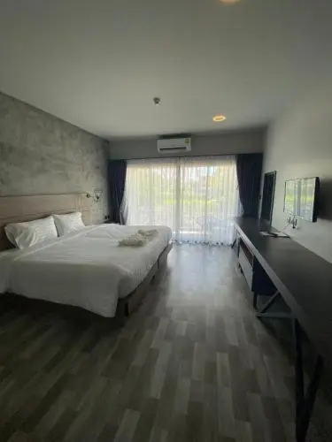 Une chambre lumineuse avec un grand lit et un bureau.