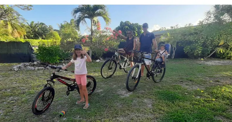 Une famille se prépare à faire du vélo sur une pelouse verdoyante.
