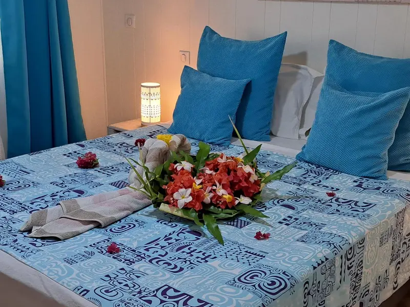 Un lit décoré de fleurs et de serviettes pliées dans une chambre.