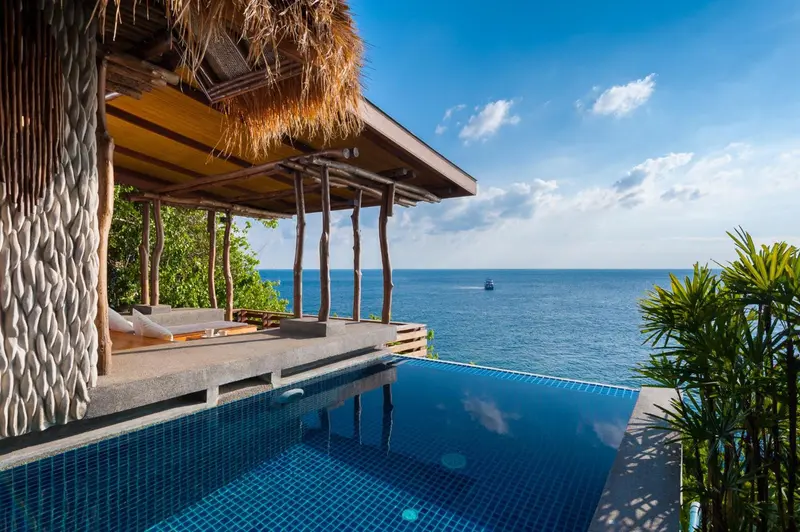 Terrasse avec piscine à débordement donnant sur la mer.