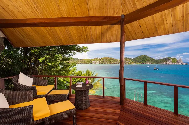 Terrasse en bois avec mobilier d'extérieur donnant sur une vue mer.
