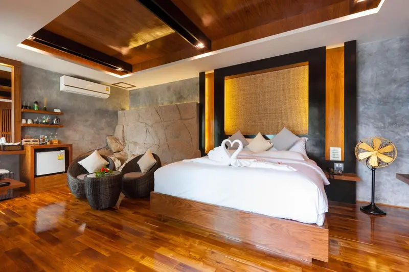 Une chambre lumineuse avec un grand lit recouvert de draps blancs et de décorations florales.