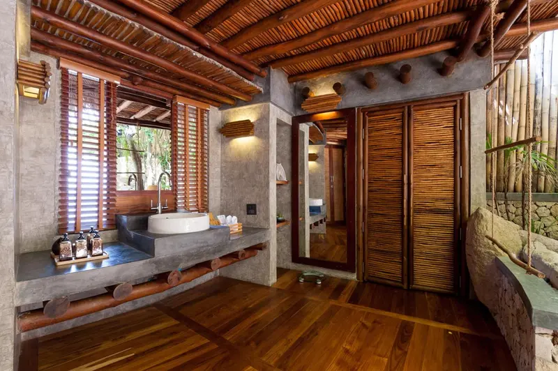 Intérieur d'une salle de bain ouverte avec vasque intégrée et murs en bois.