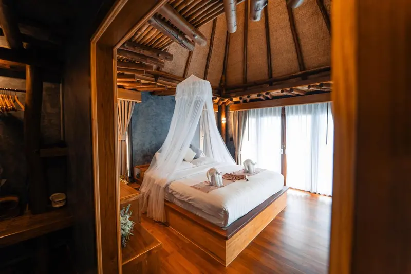 Une chambre lumineuse avec un grand lit à baldaquin et une décoration en bois.