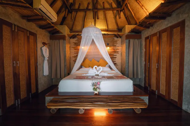 Une chambre avec un lit à baldaquin décoré de fleurs et de coussins.