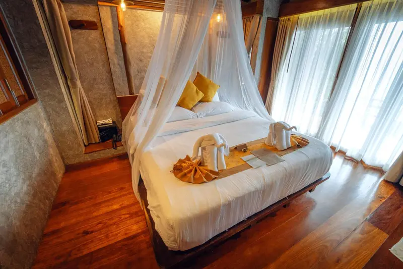 Une chambre lumineuse avec un grand lit à baldaquin et une décoration soignée.