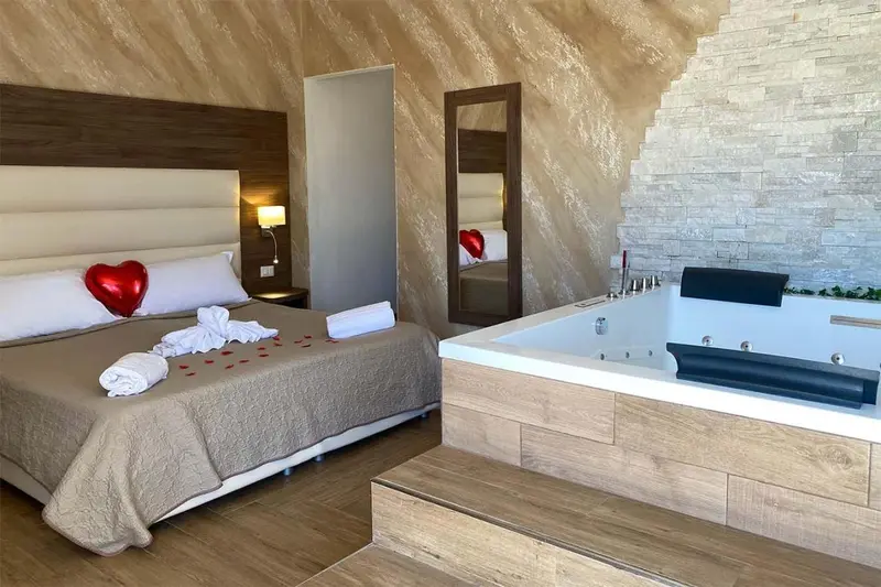 Une chambre avec un grand lit et un jacuzzi.