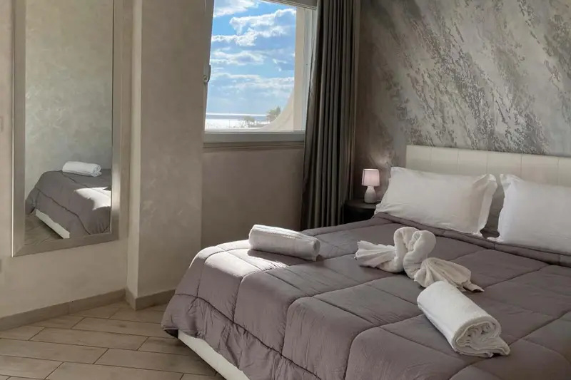 Une chambre lumineuse avec un grand lit et une vue sur la mer.